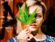 Beautiful girl with a cannabis leaf near the face